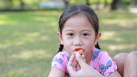 Mother feeding fruits to baby