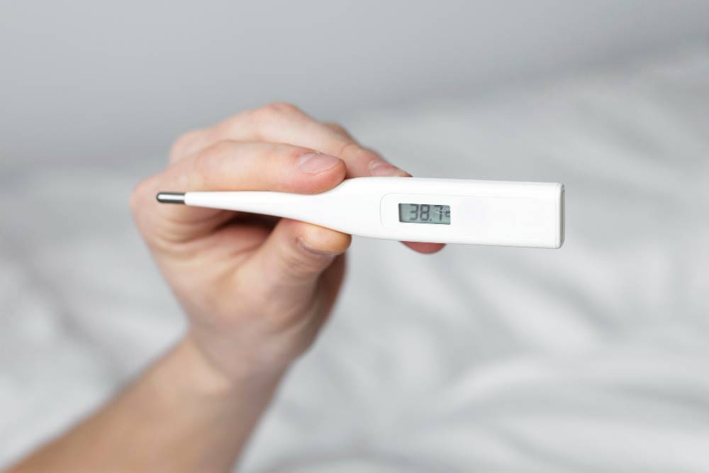 holding a thermometer for rectal temperature check