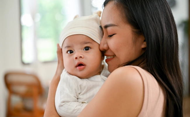 Mother keeping newborn baby close to her face.